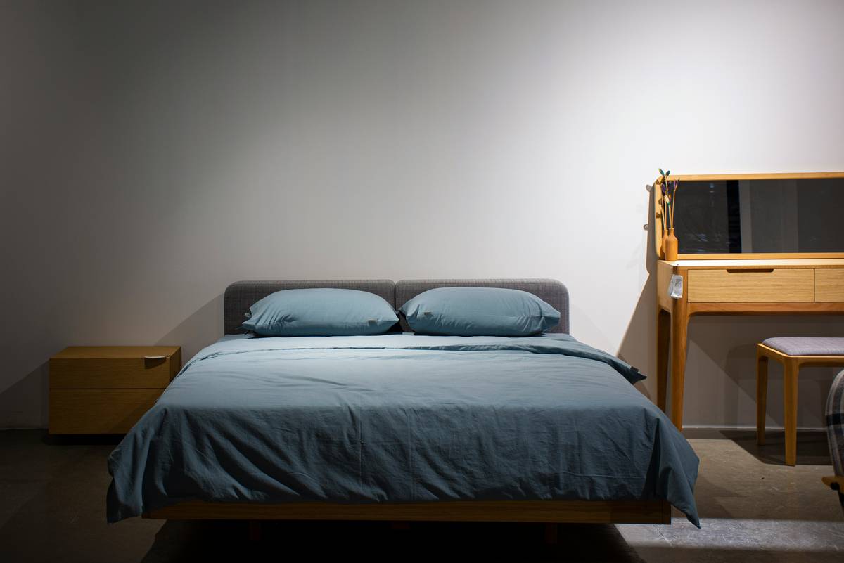 A bedroom with a bed, desk and mirror